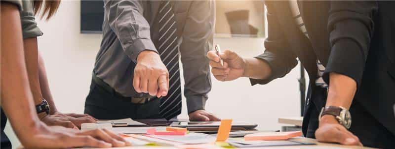 Business people pointing to table