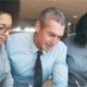 Business people gathered around table talking about business