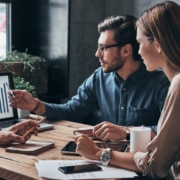 Three coworkers looking at graphs on laptop