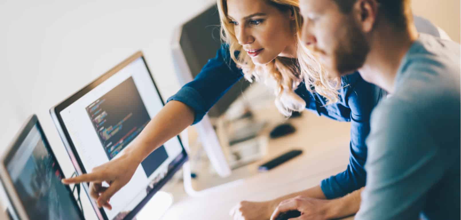 Two IT technicians working on desktop computer