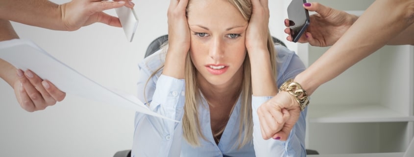 Business woman stressed with numerous people handing her papers and phones