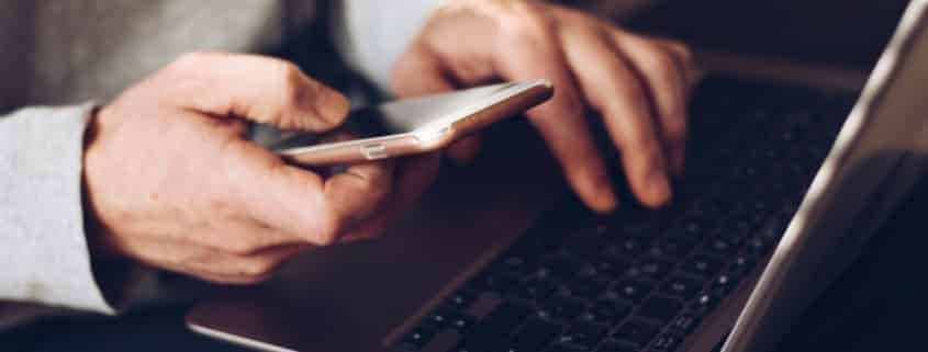 Man using laptop and cellphone