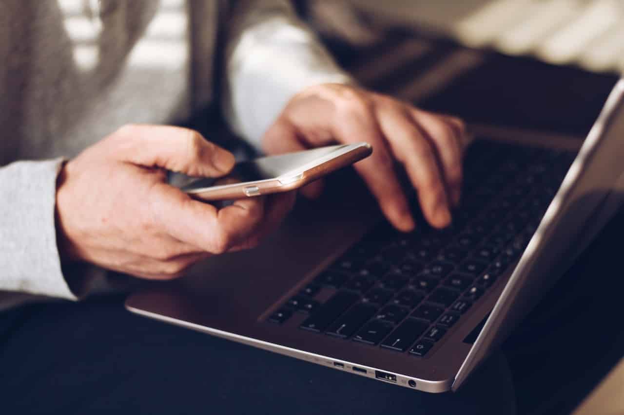 Man using laptop and cellphone