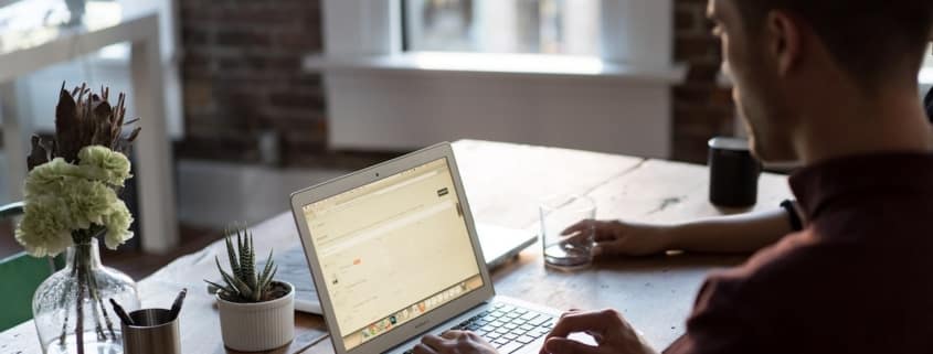 the role of firewalls in defending data - man types on laptop at table