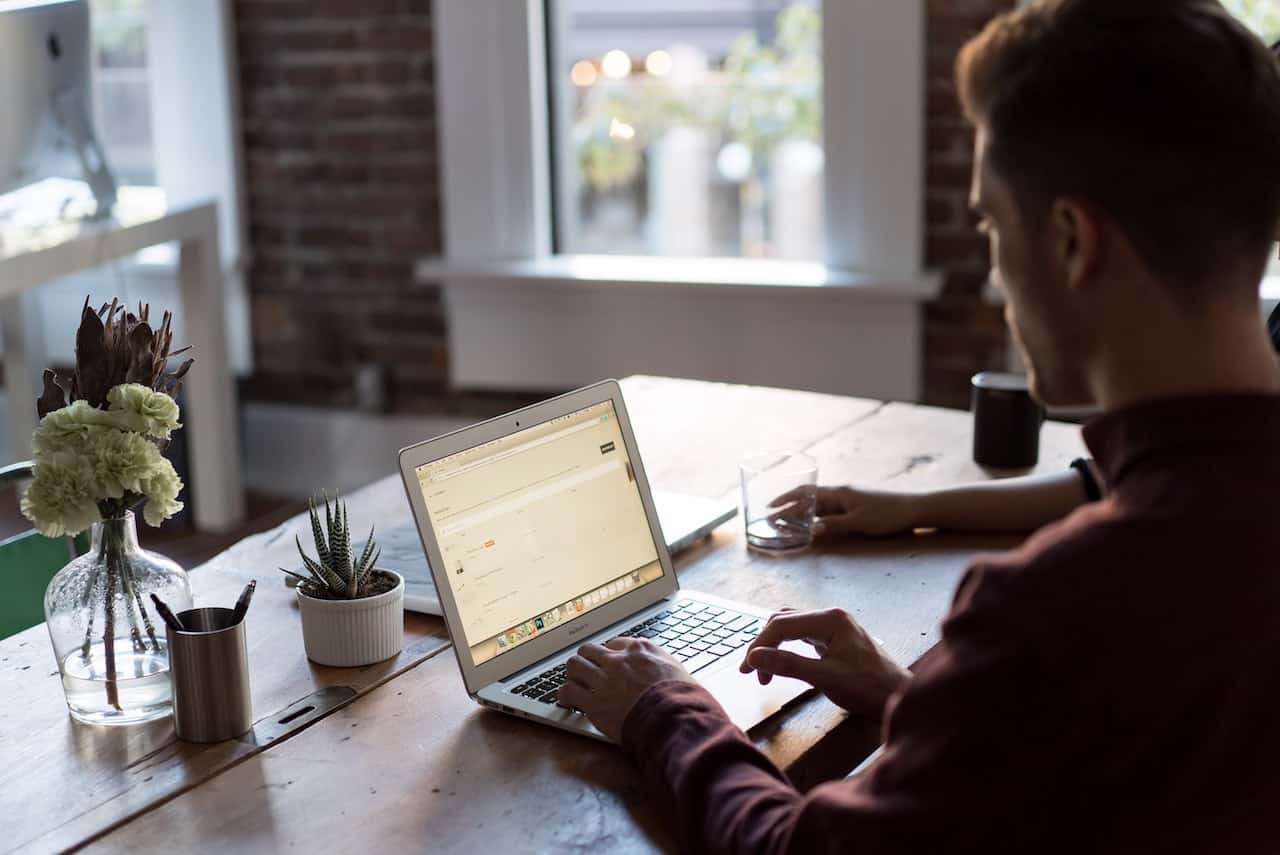 the role of firewalls in defending data - man types on laptop at table
