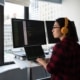 overcoming alert fatigue - employee in front of three computer screens looks out the window