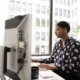 woman works at office computer to increase productivity and security through web filtering