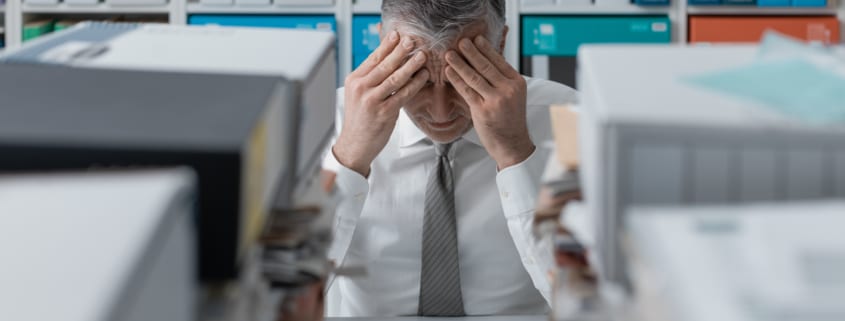 stressed Man holding his face in his hands