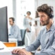 IT technician using headset while on computer