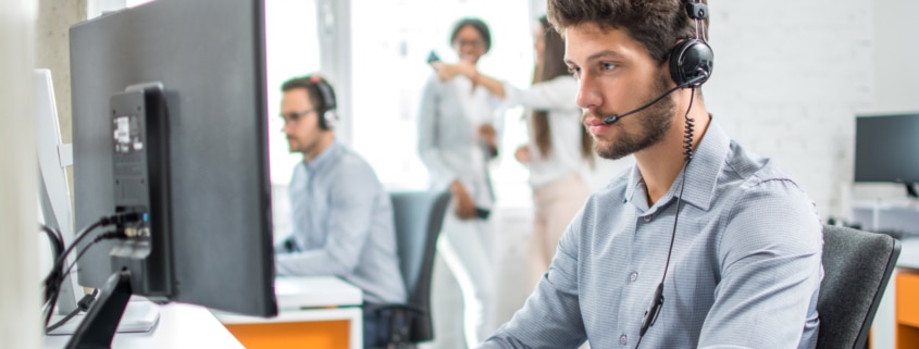 IT technician using headset while on computer