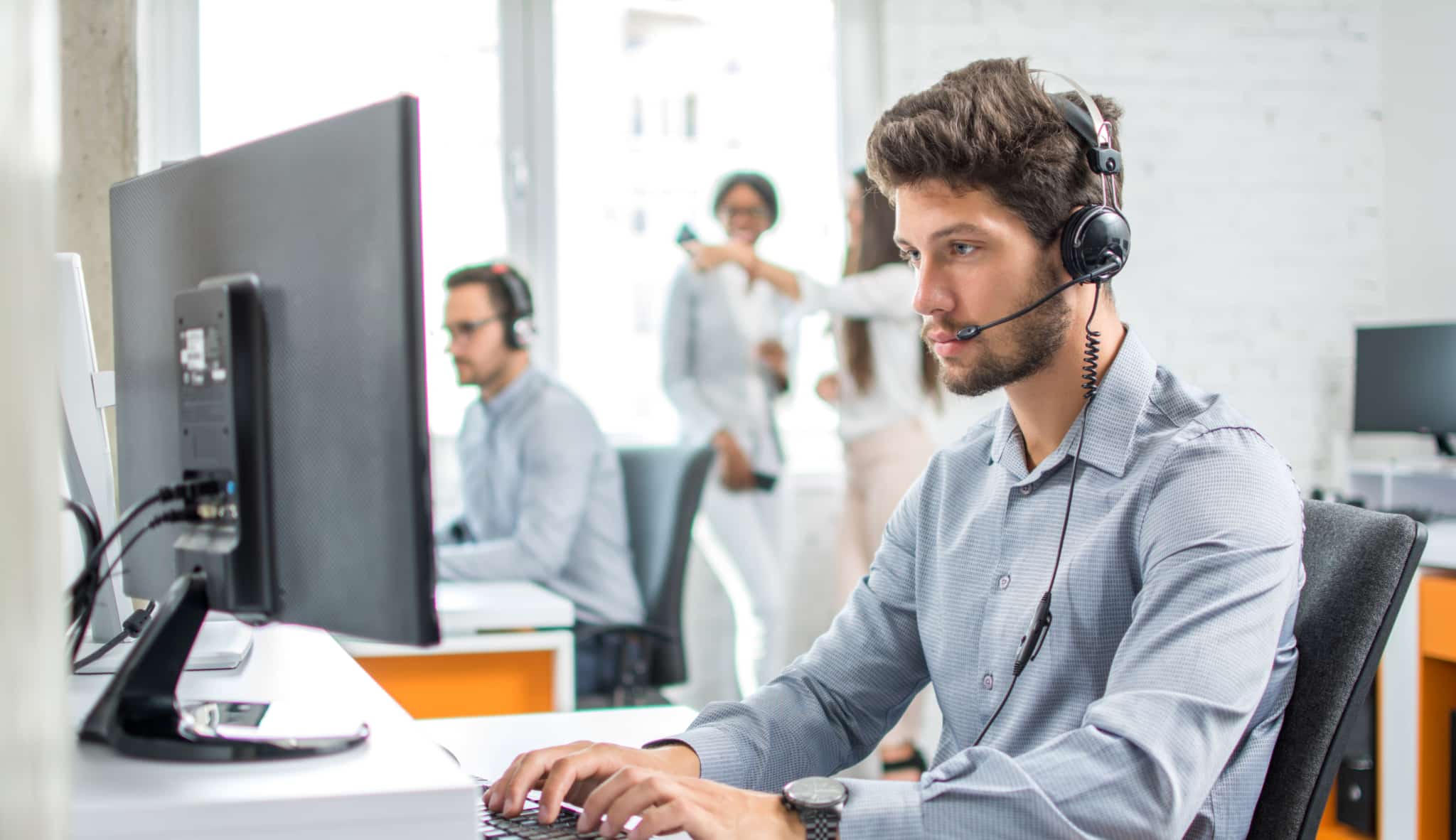 IT technician using headset while on computer