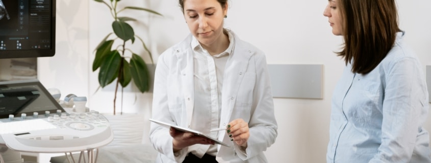 Ultra sound technician talking to pregnant woman